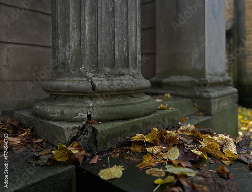 Canvas Print Old cracked stone column base with autumn leaves on the ground