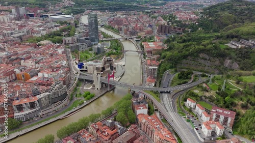 High altitude aerial view of Bilbao, Spain, iconic Guggenheim Museum, Nervion River, and surrounding cityscape in Spain