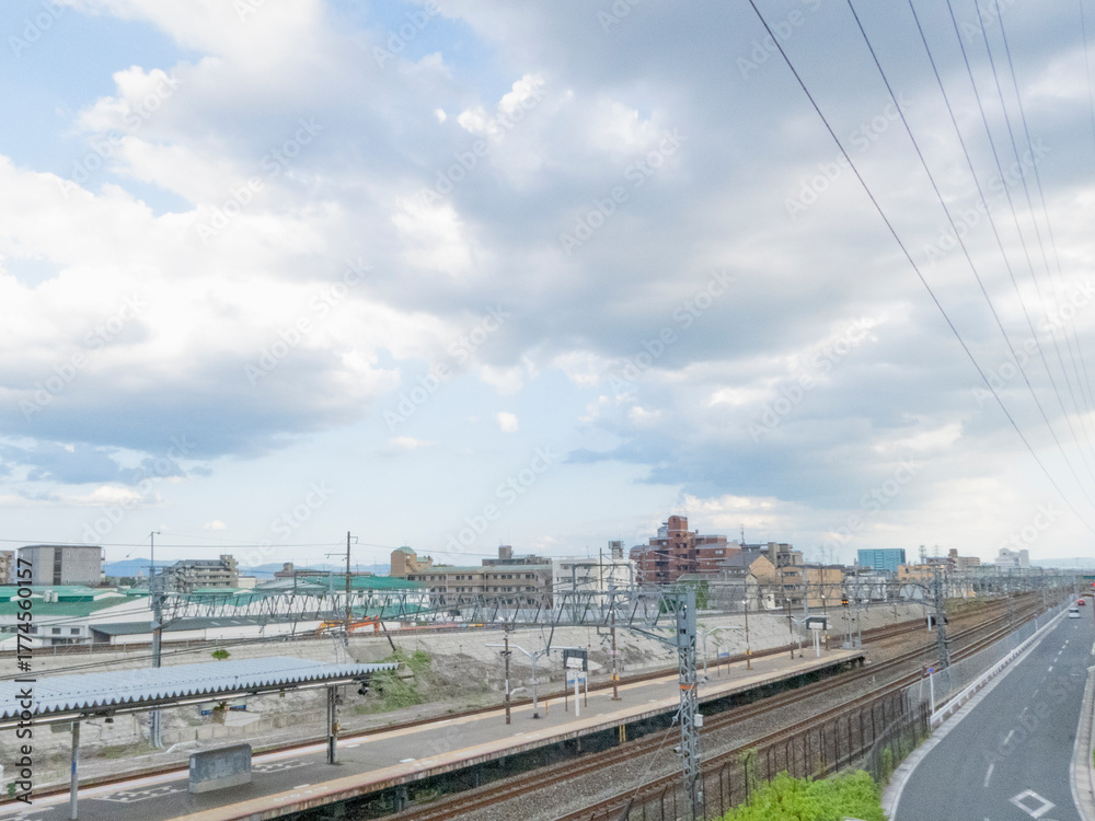Naklejka premium 曇り空の下の鉄道駅と線路、街並みの風景