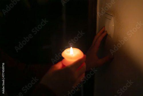 A man with a burning candle and a switch.	