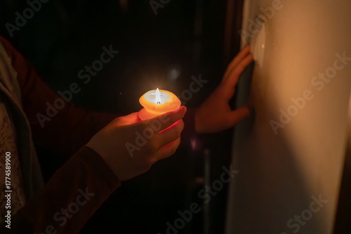 A man with a burning candle and a switch. 