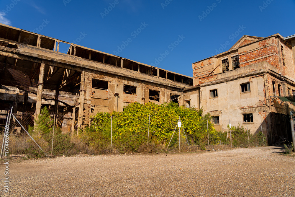 Fototapeta premium Sardinia, Italy: Abandoned Industrial Building Ruins in Southern Europe on a Sunny Day: Deterioration, Urban Decay, and Economic Decline