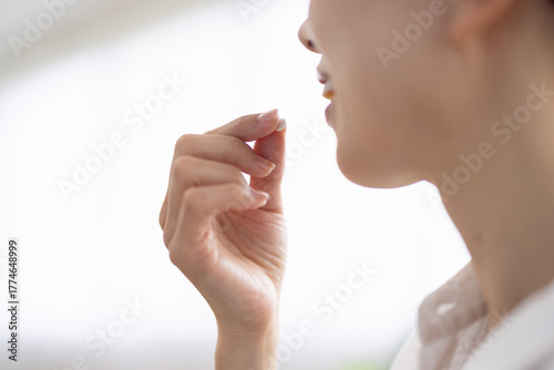 Close-up of a pill held between fingers