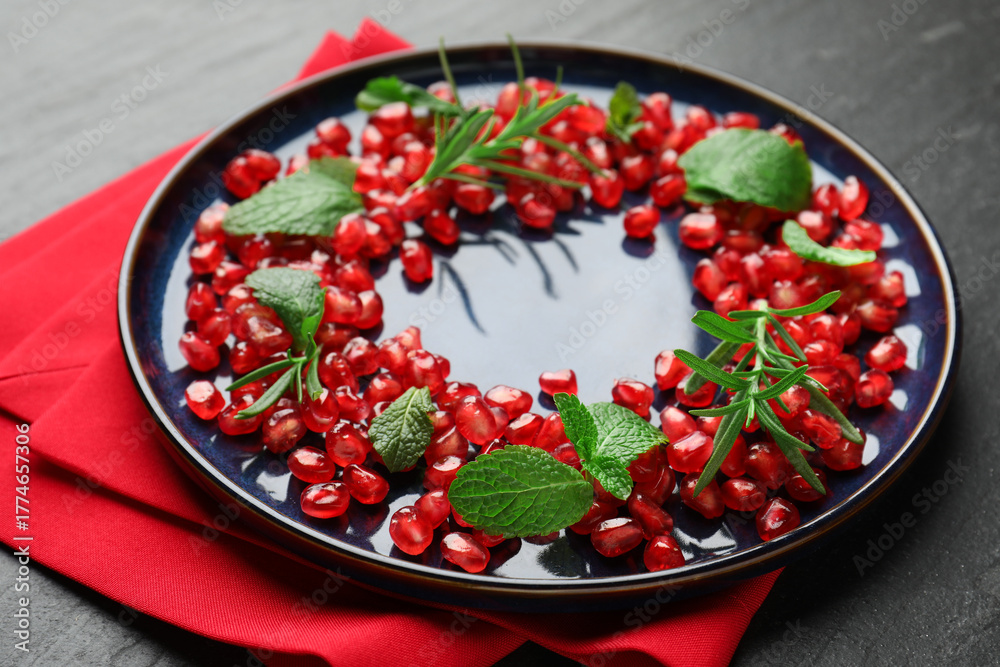Fototapeta premium Christmas food. Pomegranate seeds, mint and rosemary on dark textured table, closeup