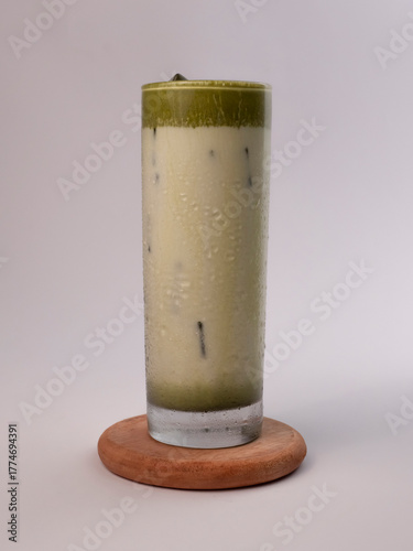 Iced matcha latte, authentic Japanese matcha latte made from Uji tea. Ice milk green tea put on white background and isolate photo style.