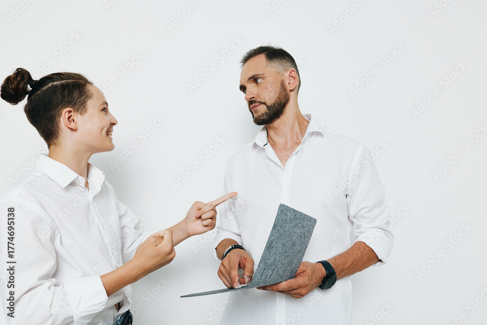 Obraz premium A professional man in a white shirt stands against an isolated colored background, exuding confidence and focus as he discusses work, showing calm determination and engaged curiosity.