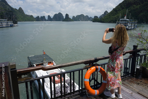 Woman photographing scenic Ha Long Bay Vietnam cruise