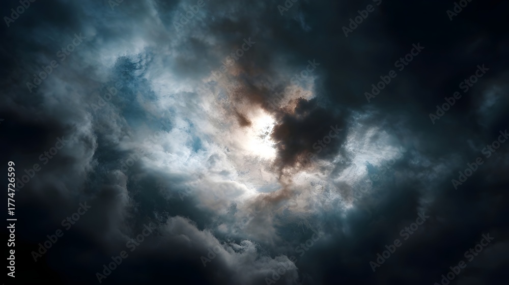 Obraz premium Dramatic storm clouds part to reveal intense sunlight breaking through the dark sky