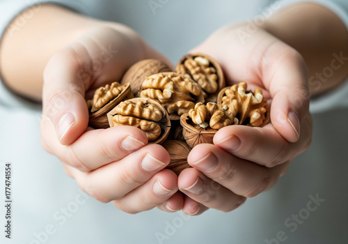 Nourishing hands cradle a generous handful of fresh, whole walnuts, bursting with natural goodness and healthy fats for your wellness journey.