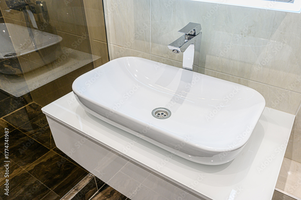 Fototapeta premium Modern bathroom featuring a sleek white rectangular vessel sink with chrome faucet