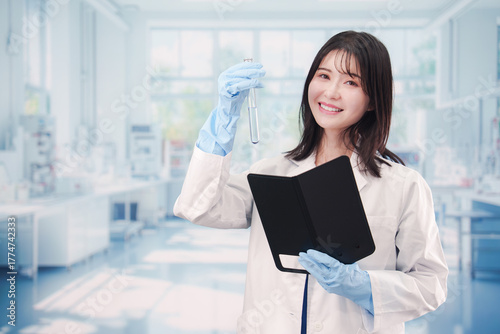 実験室で試験管の薬品を扱う若い女性