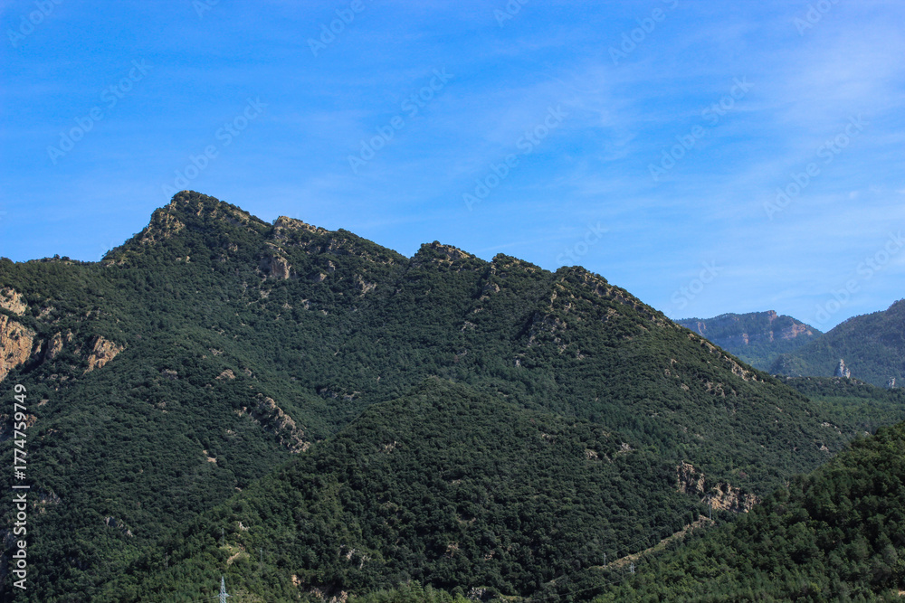 Obraz premium View from La Rodonella towards the densely forested mountain range of El Reu and Cap de Roca-roja that rises majestically above the Embassament de la Baells near La Nou de Berguedà in Catalonia