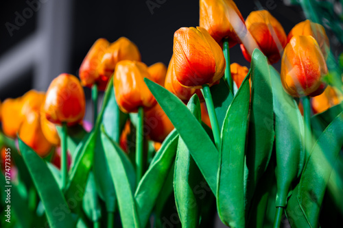 Close-up of bright artificial orange tulips with realistic texture and vibrant color