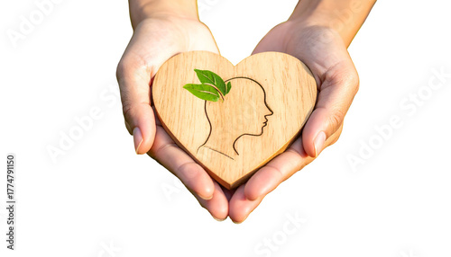 Hands cradling a wooden heart cutout with a person's head & plant, symbolizing mental health