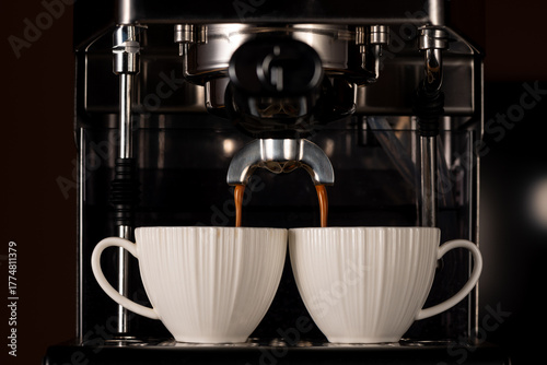 Domestic coffee maker machine preparing coffee into the two cups.