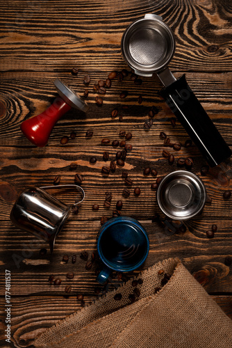Barista tools and coffee cup, top view. Wooden background with coffee beans.