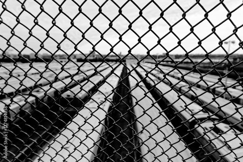 Black and White View of Train Yard Through Fence, New York City, USA