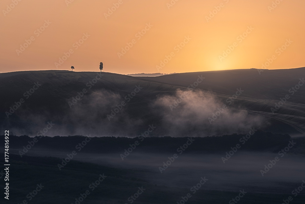 Obraz premium Misty sunrise over rolling hills in Tuscany