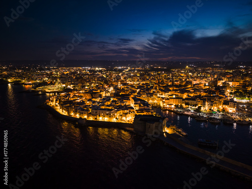 Fototapeta Naklejka Na Ścianę i Meble -  Night view of the illuminated historic center, harbor, and Carlo V Castle in Monopoli, Italy