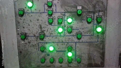 Close-up of industrial hydraulic press control panel with blinking green indicators