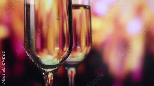 Empty wine flutes against warm pink bokeh