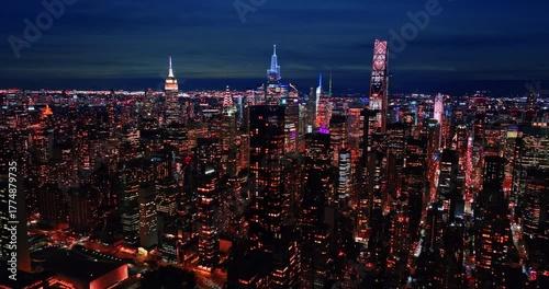 Iconic panorama of New York, USA at night time. Drone footage above the midtown approaching the famous skyscrapers tops.
