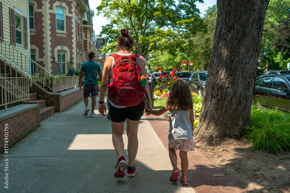 Obraz premium Mom and Daughter Holding Hands Walking Home From School