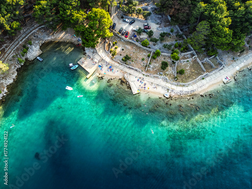 Fototapeta Naklejka Na Ścianę i Meble -  Top down aerial view of beautiful, secluded beach in the small bay of Cres island, Croatia, with beatiful, turquoise sea splashing the sand shore
