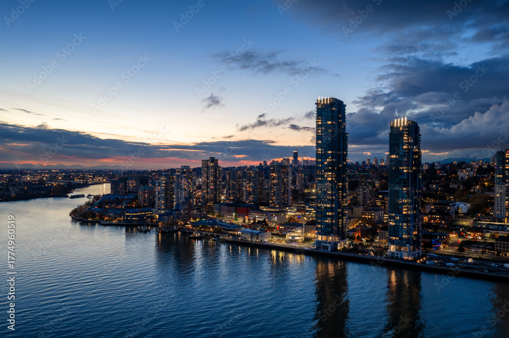 Obraz premium Evening City Skyline Over Water With Modern High-Rise Towers At Sunset