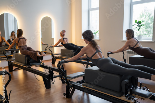 Konstfotografi Fitness instructors performing pilates exercises using reformer beds and resista