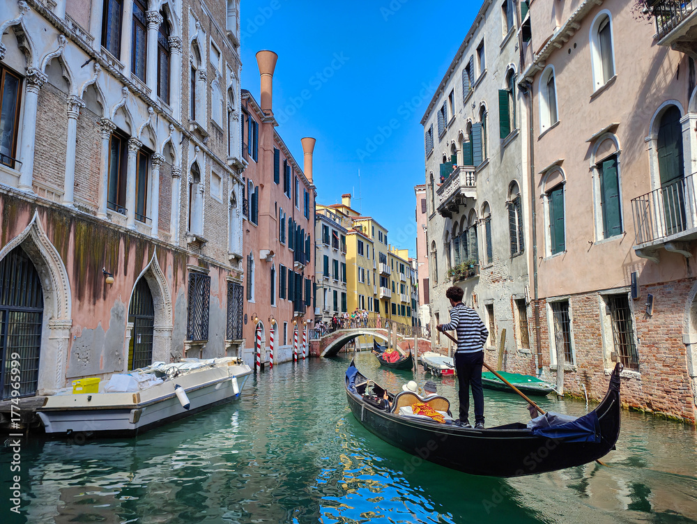 Obraz premium Scenic view of a canal with gondola and old venetian architecture on a sunny day. Venice, Italy