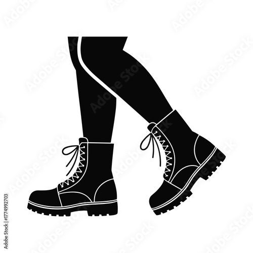 Black silhouette of legs wearing lace up combat boots with thick soles feet isolated white background.