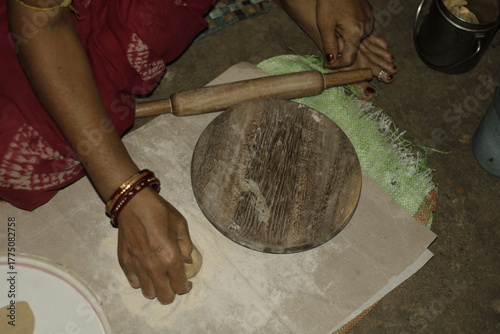 Close-up of an Indian woman’s hands rolling dough on a wooden board to make chapatis, symbolizing tradition, love, and the essence of home-cooked food in Indian households.
