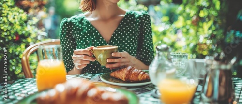 The woman enjoying a relaxed outdoor breakfast with coffee and croissant in garden