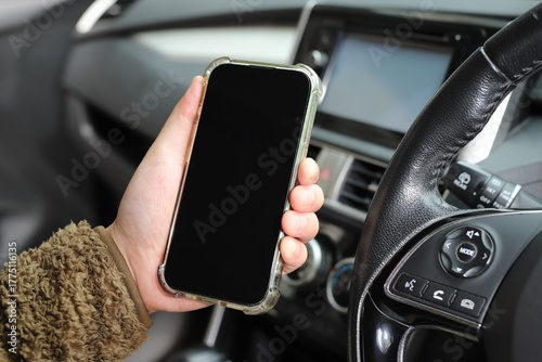Mockup of driver hand using smartphone in car.