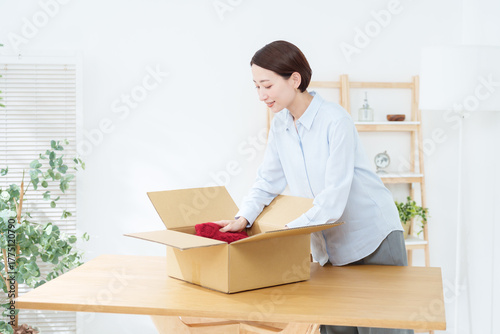 ダンボールに服を入れる女性