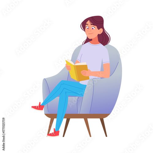 Young Woman Relaxing and Reading a Book in a Cozy Armchair