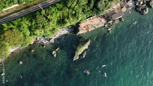 Energetic shoreline vista showcasing vessels and animated figures in view, Lively coastal imagery depicting vivid shoreline filled with colorful boats and active people