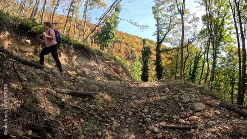 Senior woman hiking through the autumn forest