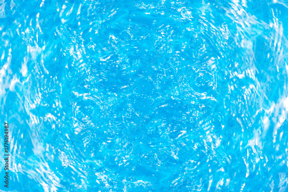 Obraz premium Blue water with ripples on the surface. Defocus blurred transparent blue colored clear calm water surface texture with splashes and bubbles. Water waves with shining pattern texture background.