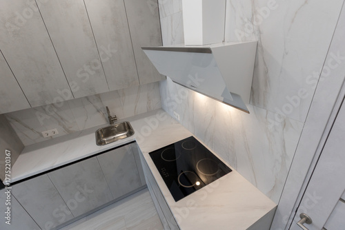 Brand new fitted kitchen with white cabinet and fully marble tiled walls