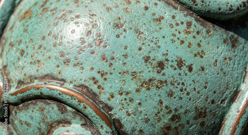 Verdigriscovered object with brown spots showing texture and corrosion on its surface