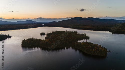 Aerial view of wooded island in lake in Maine at sunset.