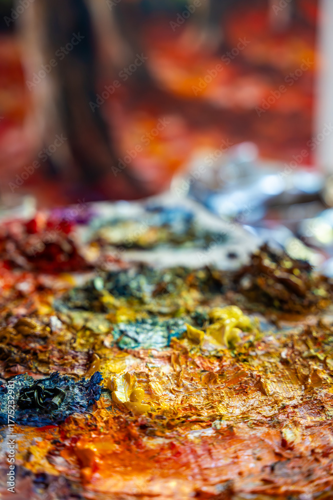 Fototapeta premium A painter at work in a cozy studio full of paintings. Capturing the artistic process and atmosphere.