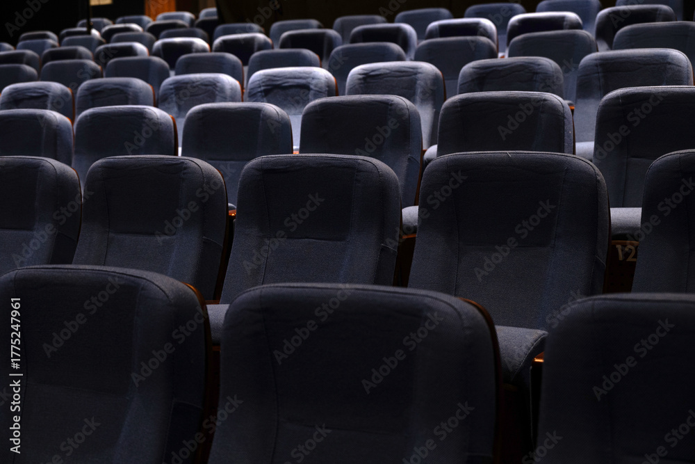 Naklejka premium Karachi, Pakistan - April 10, 2025: A captivating view of multiple rows of empty seats under dim lighting, Ideal for concepts related to education, presentations, cinema, events, or public gatherings.
