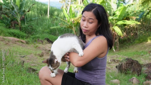 A cat is trying to escape from the woman. 