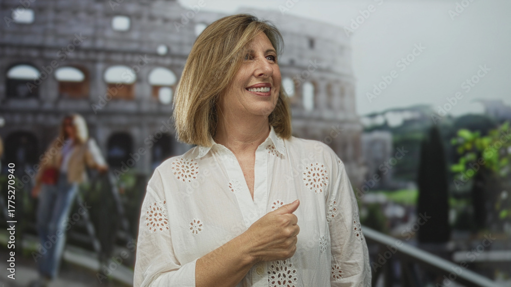 Fototapeta premium Woman in white eyelet blouse pointing finger at ancient coliseum ruins on sunny outdoor walkway near historic roman amphitheater; curiosity.