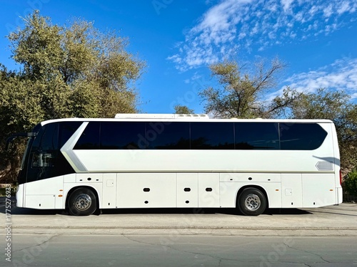 White unmarked tour bus parked waiting for passengers.