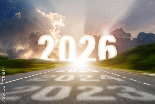 Go to the New Year 2026 concept. Road leading toward bright sunlight with bold 2026 numbers and shadows of previous years, symbolizing progress, growth, and the journey into the future.
