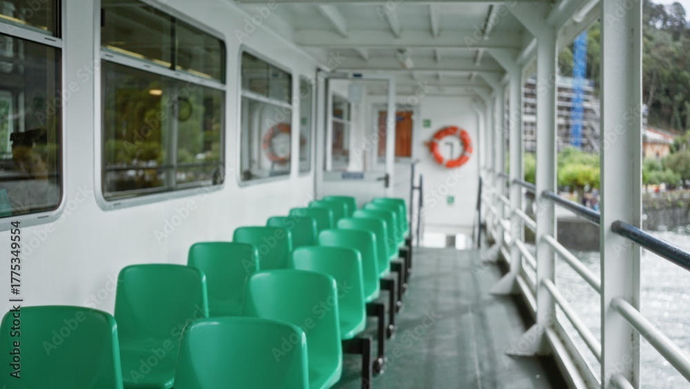 Fototapeta premium Ferry deck with rows of green plastic seats, defocused railings and distant lifebuoy interior; background backplate copyspace calm.
